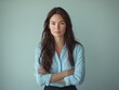 © Mandeep - woman with arms crossed looking at camera against solid background