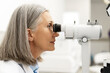 © Maria Vitkovska - Senior woman undergoing eye exam using phoropter in ophthalmology clinic