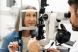 © Maria Vitkovska - Senior woman undergoing eye examination with modern equipment and doctor focusing on eye health