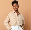 © Tondone - A confident young woman poses in a stylish beige shirt against a warm, neutral background, embodying modern fashion and elegance. Suitable for various lifestyle themes.