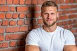 © Sanchai - A confident young guy in casual wear leaning against a brick wall, with a charming smile and vibrant urban background