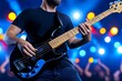 © Sanchai - A musician strumming an electric guitar on a dimly lit stage, with colorful spotlights and a cheering audience in the background