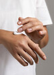 © katrinshine - Woman in white t-shirt applying cream on hand to care and protect skin closeup