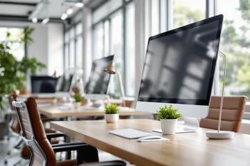 Poster - Modern workspace with desktop computers and greenery on wooden desks in a bright office environment.