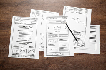 Leinwandbilder - Developing UI design. Sketches of website wireframes and pencil on wooden table, top view