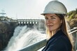 © Viktoriia - Confident woman in hard hat oversees powerful waterfall at hydro