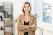 © New Africa - Portrait of happy businesswoman with crossed arms in office
