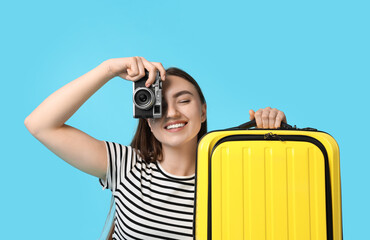 Sticker - Woman with vintage camera and suitcase on light blue background