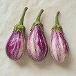 © Ishika - three striped eggplants on a white cloth