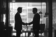 © Ishika - two men in suits shaking hands in an office