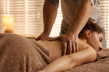 Wall Mural - Osteopath massaging woman's back on couch indoors, closeup. Manual therapy