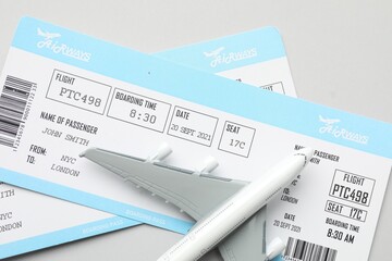 Sticker - Travel agency. Flight tickets and plane model on grey background, flat lay