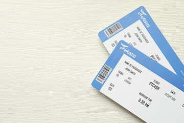 Sticker - Travel agency. Flight tickets on light wooden table, top view. Space for text