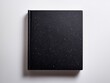 © Erich - Hardcover black book with white specks lying on white background