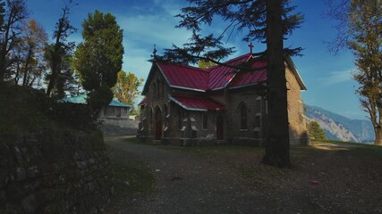 Wall Mural - Facade of virgin Mary church with red roof surrounded by greenery and blue sky in Ayubia, Pakistan