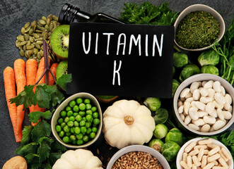 Wall Mural - Foods high in vitamin K on dark background.