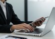 © Muaz - Business Professional Multitasking with Laptop and Tablet at Office Desk