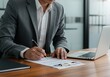 © Muaz - Business Professional Signing Document at Desk with Laptop and Pen