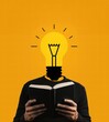 © kraphix - A person holding a book with a light bulb for a head against a yellow background.