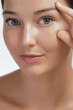 © Buyanskyy Production - A close-up of a woman gently touching the skin around her eye, focusing on her radiant complexion and smooth skin. Ideal for beauty, skincare, and anti-aging campaigns promoting facial care and