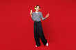 © ViDi Studio - Full body young happy woman she wear blue striped sweatshirt casual clothes listen to music in headphones hold in hand use mobile cell phone isolated on plain red background studio. Lifestyle concept.