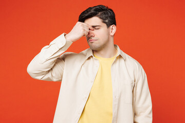 Poster - Young sad sick ill tired exhausted man wear white shirt yellow t-shirt casual clothes keep eyes closed rub put hand on nose isolated on plain red orange background studio portrait. Lifestyle concept.