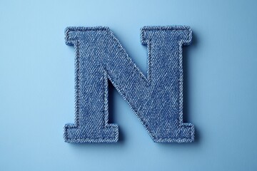 Fototapete - The letter N is made out of denim and is blue in color