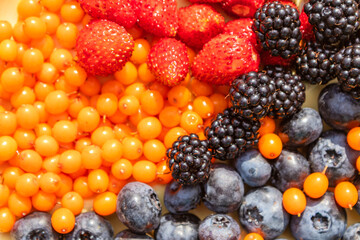 Wall Mural - Mixed various berries collected on the plot, assorted berries of blackberries, strawberries, blueberries, sea buckthorn. Colorful and healthy concept. Black, blue, red, green. close up