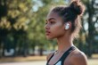 © alphaspirit - Young sporty woman wearing wireless earbuds listening to music in park
