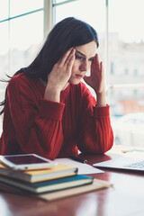 Fototapete - Tired puzzled woman using  modern laptop computer for watching bad tutorials indoors, concentrated unhappy caucasian hipster girl sitting at cafeteria and using new netbook for studying online