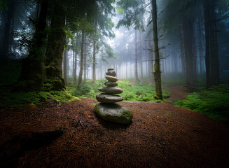 Poster - A serene stone cairn stands amidst a mystical, fog-laden forest.  The tranquil scene evokes a sense of peace and hidden mystery.