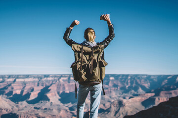 Wall Mural - back view of female tourist celebrating victory getting to mountain top raising hands up, hipster gi