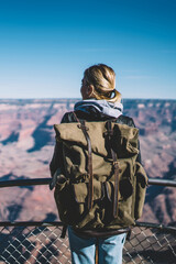 Wall Mural - back view of female american traveler standing on touristic viewpoint enjoying beautiful nature of n