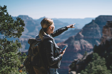 Wall Mural - positive female traveler with backpack satisfied with application for checking direction during rout