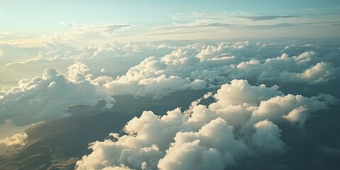 Aerial view of land and clouds captured from an airplane, showcasing the stunning interplay of terrain and cloud formations visible during the flight from the airplane perspective.