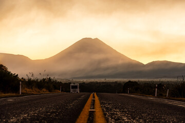 Wall Mural - Volcanic Mount Ngauruhoe with golden sky in foggy over highway road at Tongariro national park, New Zealand