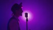 © kinomaster - Man musician in stylish hat standing on dark concert stage against purple spotlight and singing in retro microphone, isolated on black studio background.