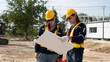 © somchaikhun - A Caucasian white civil engineer, architect, or construction worker is wearing a safety suit while inspecting building construction on site and verifying blueprints or drawing plans.