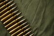 © Viktor - Many rifle bullets on military camo green fabric background