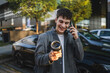 © Miljan Živković - young man with thermos talk on mobile phone man in the parking lot