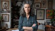 © bulegendut - Confident mature woman with gray hair, arms crossed, in a home studio.