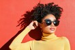 © EvgeniiasArt - Stylish young african female with sunglasses against vibrant red background