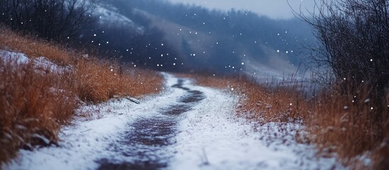 Aufkleber - Serene winter pathway winding through snow-covered mountains and gently falling snowflakes in a tranquil landscape scene
