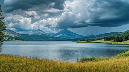Aufkleber - Dramatic overcast sky reflecting on tranquil lake with mountains and lush greenery in serene landscape scene