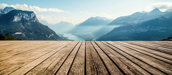 Poster - Scenic view from a wooden terrace overlooking majestic mountains and a serene lake in the distance during a sunny day