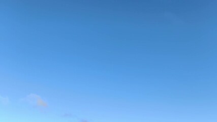 Sparse clouds moving across the blue sky in the morning