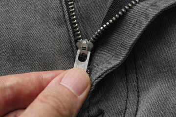 Wall Mural - A man unzipping the fly on jeans. Close up.