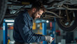 © Nadiya - Mechanic working diligently under a car in an auto repair shop