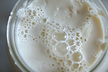 Poster - Close up of milk with bubbles forming intricate patterns inside a glass jar, creating a visually appealing texture