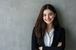 © Kavidu - Happy Young Business Woman Smiling Confidently in Professional Attire Posing Against Grey Background